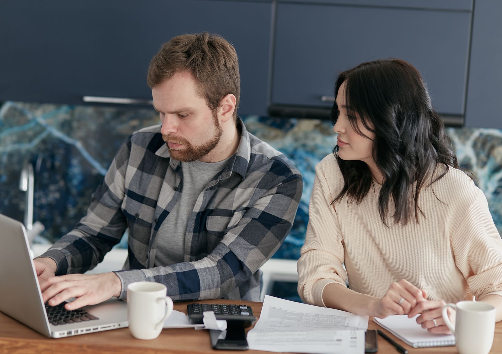A couple reviewing household paperwork together at their kitchen table